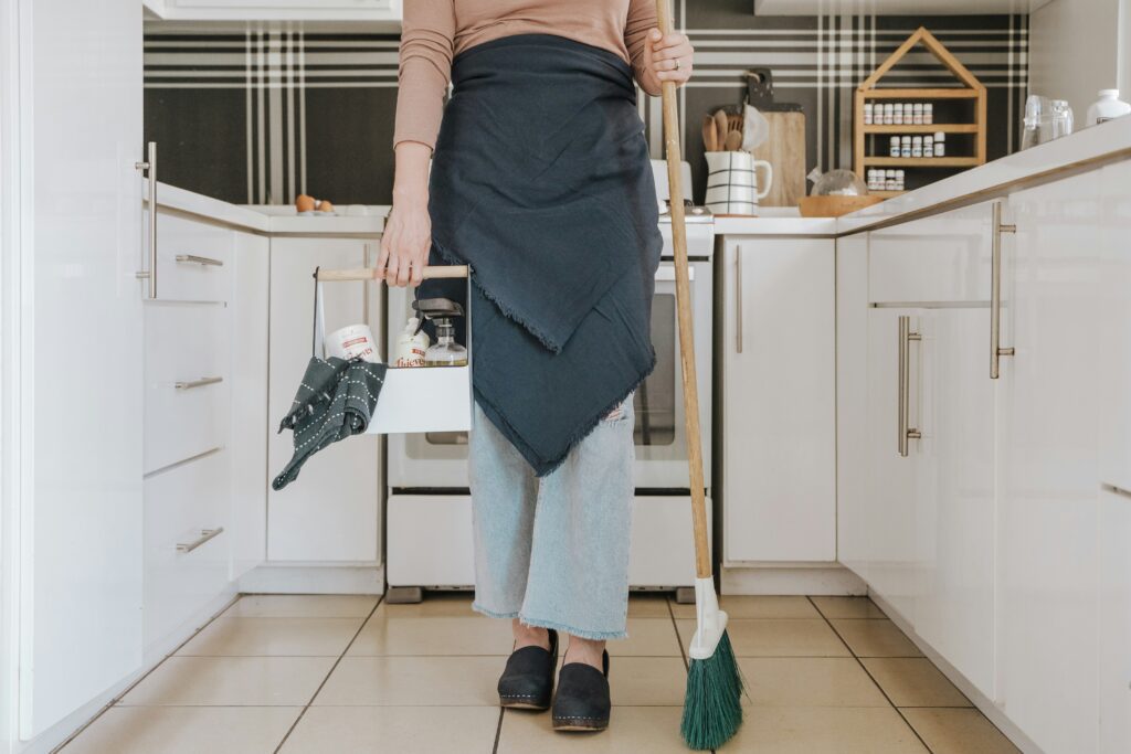Cleaning professional in apron preparing to clean residential kitchen