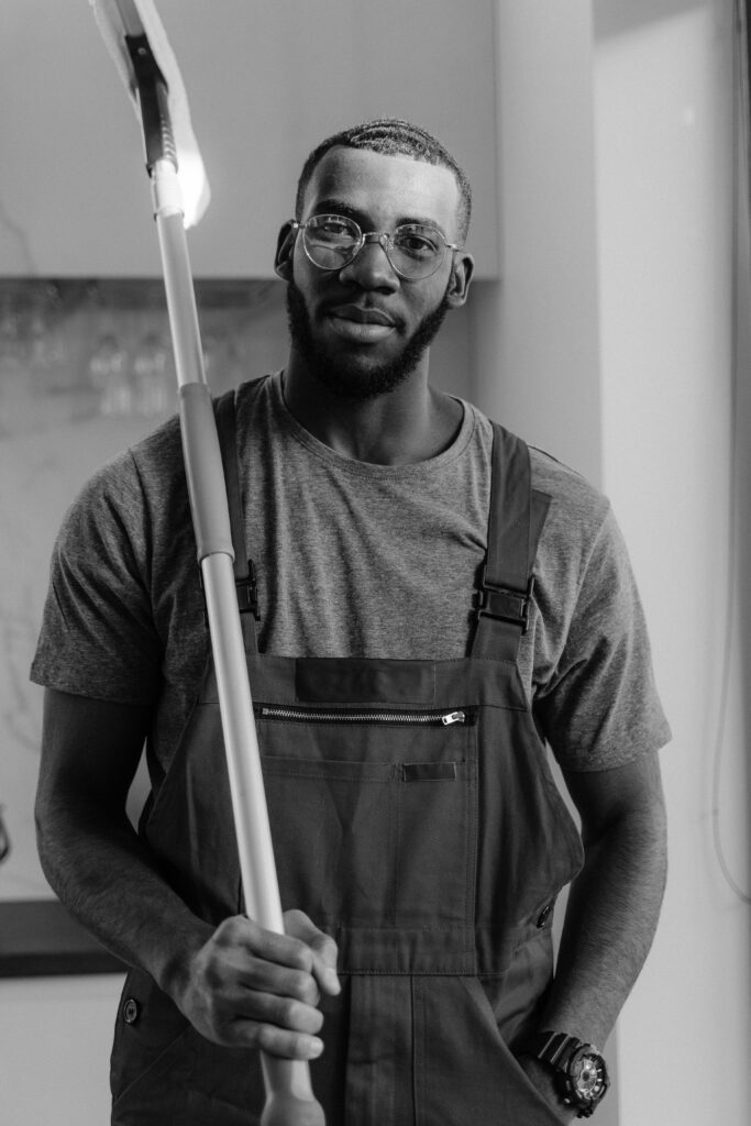 Professional cleaner in gray uniform holding cleaning mop