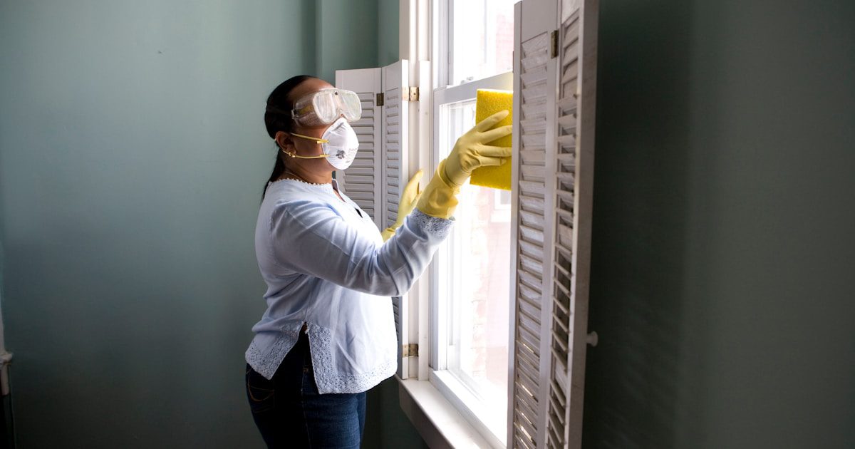 Professional cleaner wiping down a vacation rental kitchen